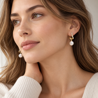 Pearl dangle earrings worn by woman